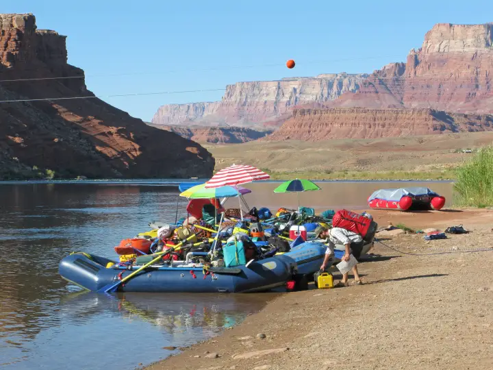 Fully rigged rafts tied up along the sandy shore at the Lees Ferry launch ramp